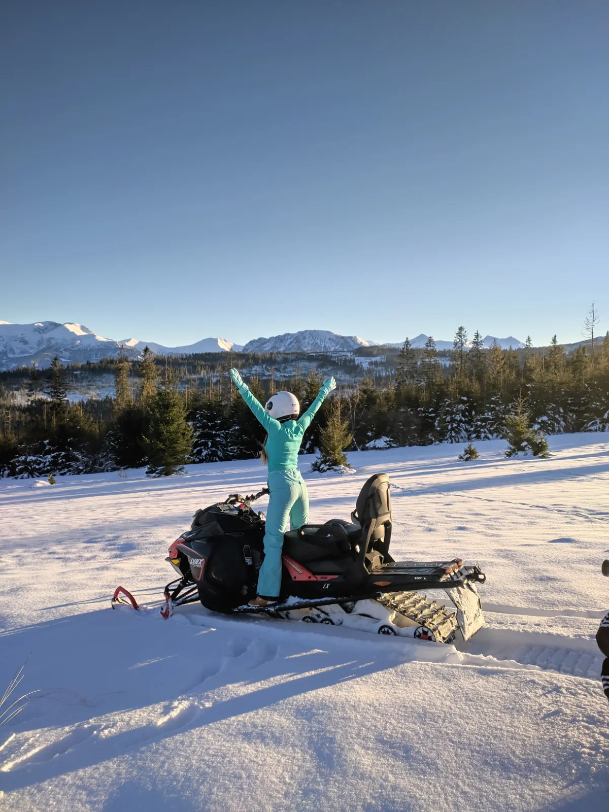 Guest with snowmobile and panoramic winter view of the Tatra Mountains