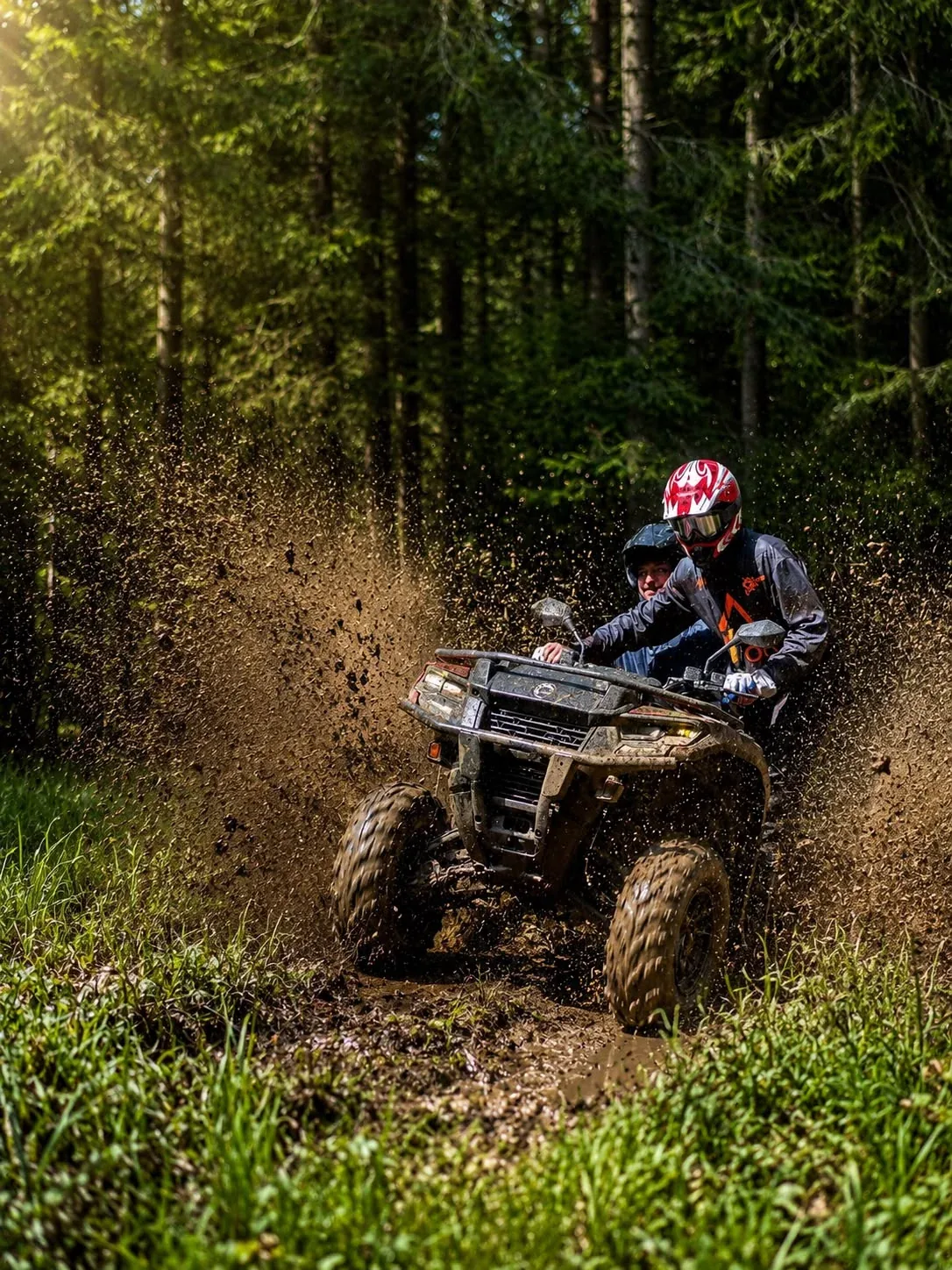 Quad bike riding through mud on an off-road forest trail near Zakopane