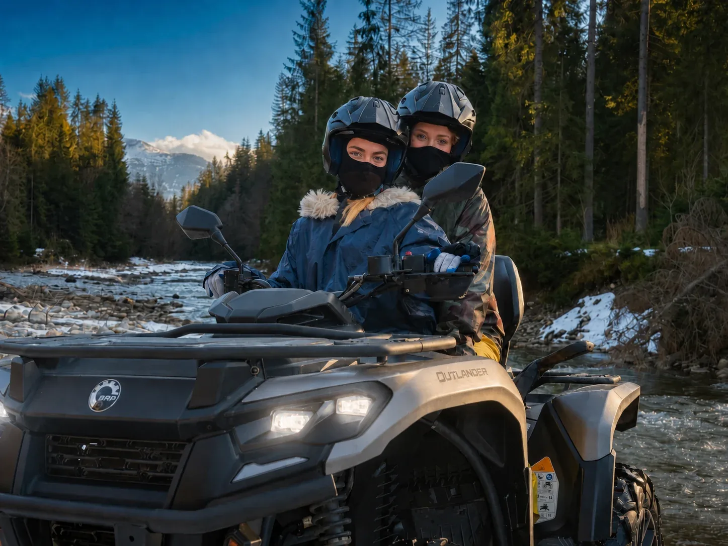 Two guests sharing a quad bike beside a mountain river in the Zakopane region