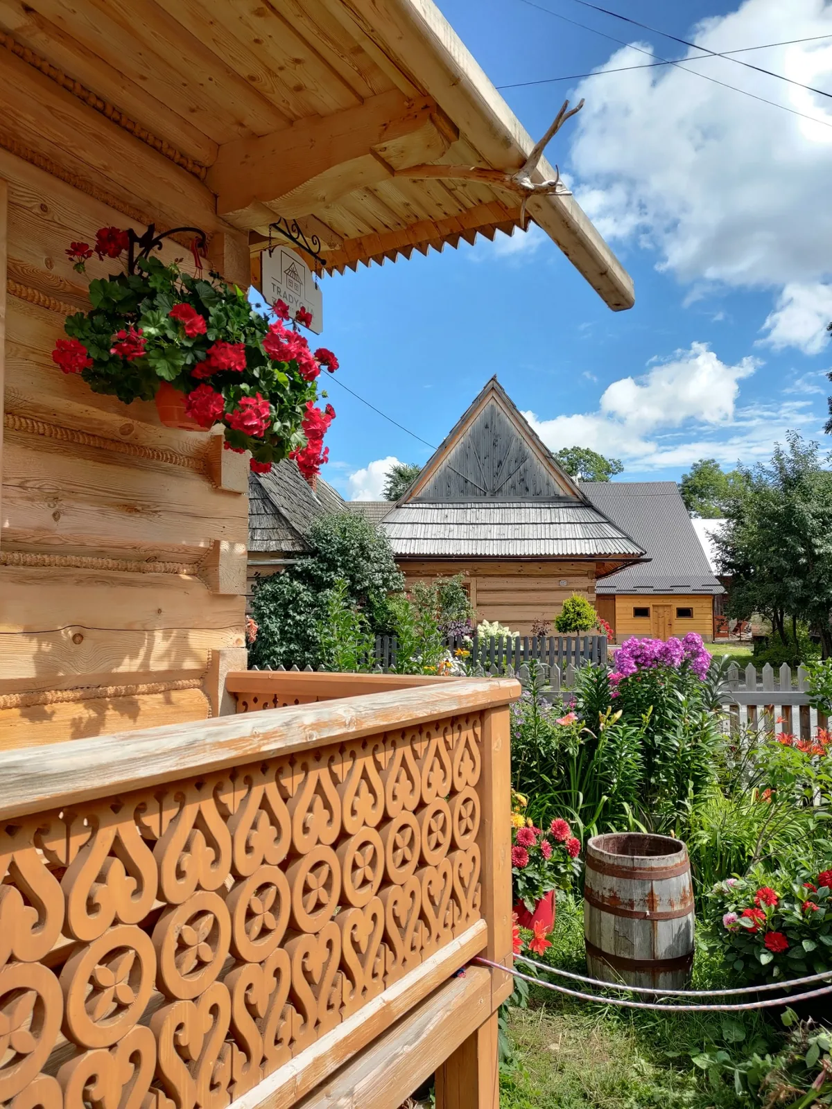 Carved wooden porch with flowers in Chocholow